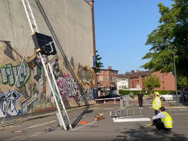 Workers using Power Ladder Rental for rooftop material lift