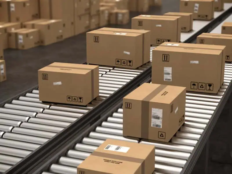 Automated Gravity Conveyor Design carrying labelled cardboard boxes in a distribution centre.