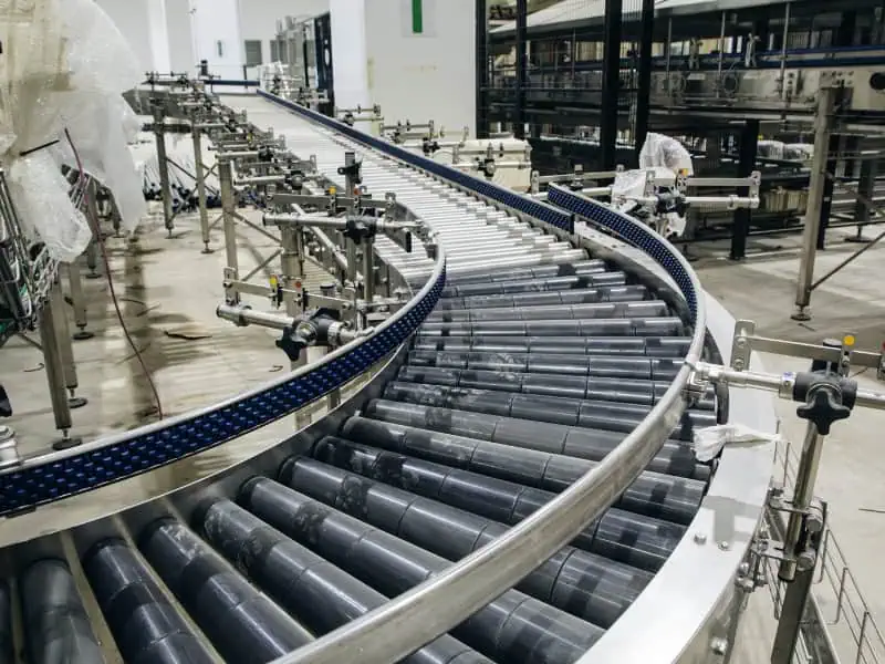 Curved roller conveyor application in warehouse production line with metal rollers and adjustable support frames