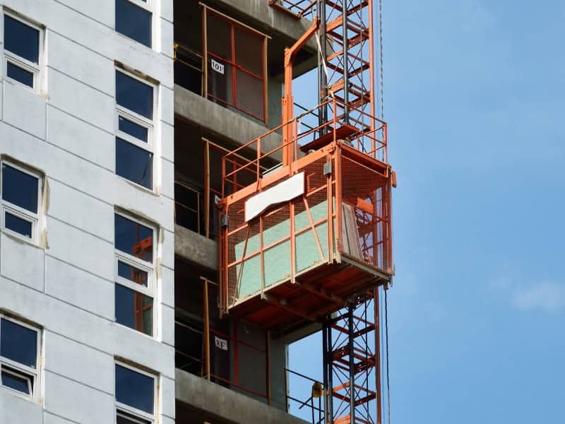 suspended hoist in construction lifting materials on high-rise building