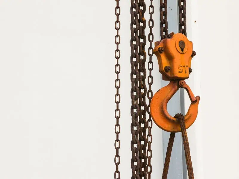 Construction Material Lifts chain and hook system supporting heavy loads on-site.